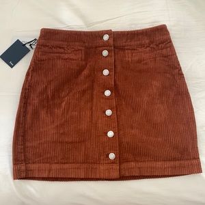 Cute corduroy tan skirt with buttons. Perfect for fall! Never worn, with tags.